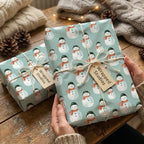 Cute snowman Christmas wrapping paper by Wrapped Studios on cozy holiday gifts tied with twine.
