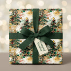 Watercolor Christmas tree wrapping paper with a green ribbon bow on a holiday gift box by Wrapped Studios.