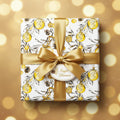 Elegant Christmas gift wrapped in gold ribbon and festive ornament pattern paper.