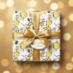 Elegant Christmas gift wrapped in gold ribbon and festive ornament pattern paper.