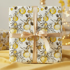Elegant Christmas gift wrap featuring golden ornaments and pinecone design, tied with a satin ribbon.