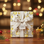 Elegant Christmas gift wrapped in white paper with a gold ornament pattern and a white ribbon.
