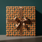 Coffee bean wrapping paper with a brown satin bow on a gift box by Wrapped Studios.