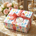 Religious baptism wrapping paper with watercolor crosses and pink ribbon by Wrapped Studios.
