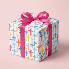 Watercolor cross wrapping paper with a pink bow for baptism, Easter, or christening by Wrapped Studios.