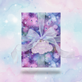 Purple rain-themed wrapping paper with sheer ribbon and "A little bit magic" gift tag.