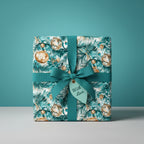 Teal ribbon on Christmas gift wrap with gold ornament pattern and "With Love" tag. Wrapped Studios.