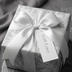 Luxury floral wrapping paper with a white satin bow and 'With Love' tag by Wrapped Studios.