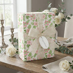 Elegant watercolor pink floral wrapping paper with cream ribbon and congratulations tag by Wrapped Studios.