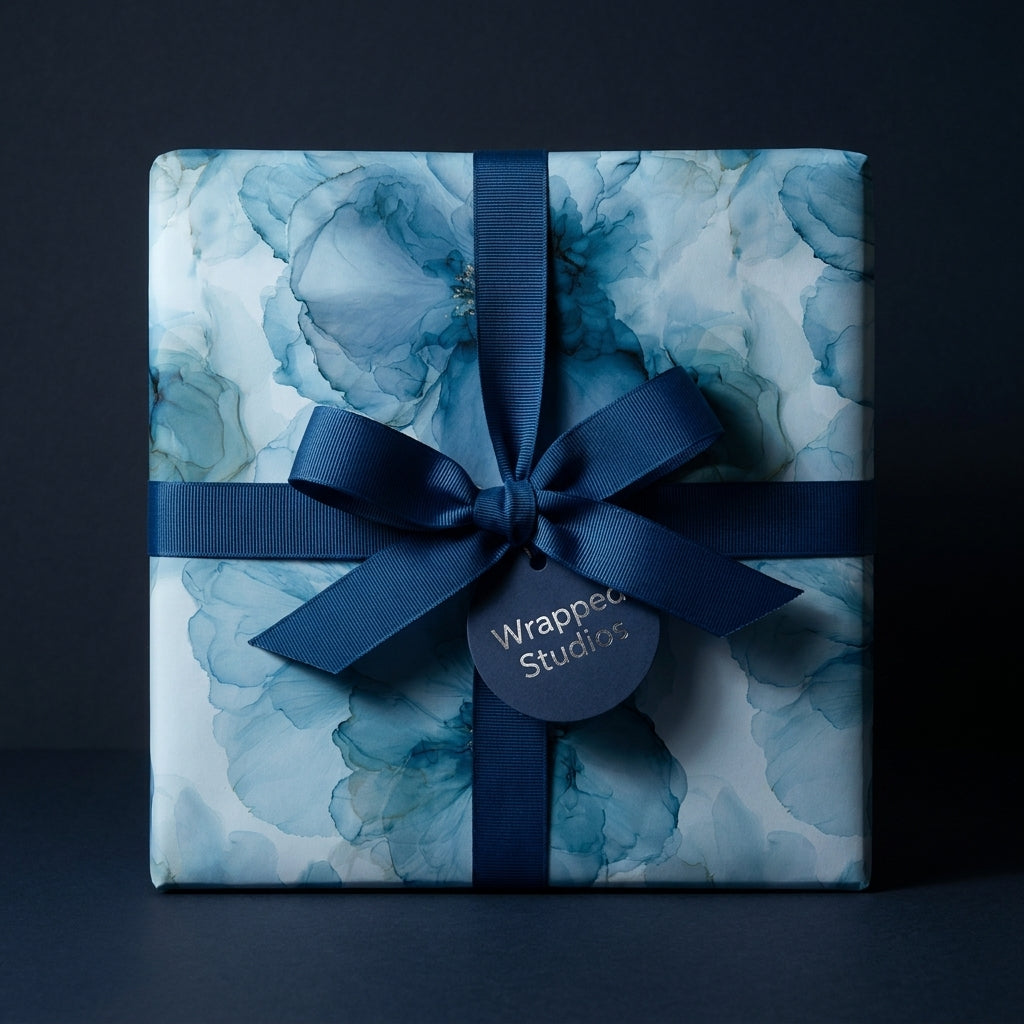 Luxury blue watercolor floral wrapping paper with a navy ribbon and tag from Wrapped Studios.
