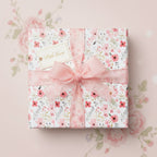 Square gift wrapped in floral wrapping paper with pink ribbon and bow, and a "With Love" tag.