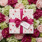 Elegant gift box in floral wrapping paper with pink ribbon, perfect for birthday or bridal shower.