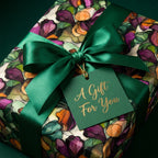 Elegant floral wrapping paper with a satin green ribbon and "A Gift For You" tag. Wrapped Studios.