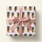 Pink graduation wrapping paper with watercolor roses, graduate caps, and a satin bow by Wrapped Studios.