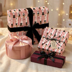 Graduation wrapping paper with pink graduate illustration and black velvet bows by Wrapped Studios.