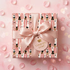 Pink graduation wrapping paper with female grads, satin bow, and Congrats Grad tag by Wrapped Studios.