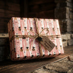 Pink graduation wrapping paper with watercolor graduates and a rustic twine bow by Wrapped Studios.