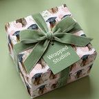 Graduation wrapping paper with watercolor floral design and green velvet bow, by Wrapped Studios.