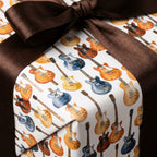Watercolor electric guitar wrapping paper with a brown satin bow by Wrapped Studios.