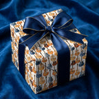 Guitar wrapping paper by Wrapped Studios on a gift box with a navy satin ribbon on blue velvet.