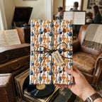Blue and orange retro guitar wrapping paper by Wrapped Studios, tied with black twine.