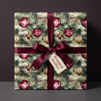 Wrapped gift in watercolor Christmas ornament wrapping paper with burgundy ribbon.