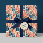 Whimsical owl wrapping paper with navy blue ribbon for baby shower and birthday gifts, by Wrapped Studios.