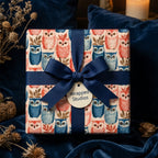 Whimsical owl wrapping paper with a navy blue ribbon bow and gift tag by Wrapped Studios.