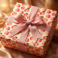 Watercolor peach wrapping paper with a pink ribbon bow on a birthday gift box, by Wrapped Studios.