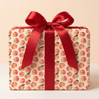 Watercolor apple wrapping paper with a red satin ribbon on a gift box by Wrapped Studios.