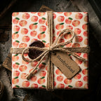 Rustic apple wrapping paper by Wrapped Studios on a gift box tied with twine and a wax seal.