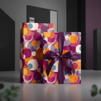 Modern gift boxes wrapped in colorful geometric circle wrapping paper with a plum purple ribbon.