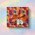 Colorful abstract pattern birthday wrapping paper with orange ribbon on a gift box, tag reads "Happy everything!".