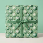 Sage green Christmas wrapping paper with festive ornaments and matching satin ribbon by Wrapped Studios.