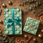 Sage green Christmas wrapping paper with ornament pattern and teal ribbon by Wrapped Studios.