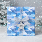 Blue watercolor cloud Christmas gift wrap with silver ribbon bow and star ornament.
