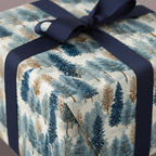 Elegant Christmas gift wrapped in blue and brown winter tree wrapping paper with a navy ribbon.