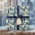 Christmas gift wrapped in winter forest wrapping paper, tied with a navy ribbon and tag.