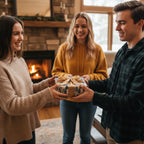 People exchanging a gift wrapped in elegant tree-print wrapping paper with a gold ribbon in cozy home setting.
