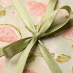 Elegant floral wrapping paper with watercolor figs and a sage green ribbon by Wrapped Studios.