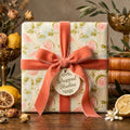 Vintage botanical wrapping paper with pink fruit and coral velvet ribbon by Wrapped Studios.