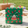 Summer watermelon wrapping paper with green ribbon and "Sweet Summertime Surprise!" tag, perfect for birthday gifts or picnic parties.