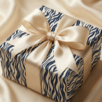 Elegant gift wrapped in modern navy zebra print paper with a satin bow.