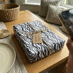 Modern graduation gift wrapped in black & white zebra print paper with a twine bow and "Congrats, Graduate" tag.
