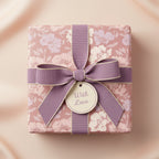 Elegant floral wrapping paper with mauve bow and "With Love" tag, perfect for wedding or birthday gift.