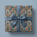 Vintage Christmas wrapping paper with festive wreaths and a blue satin ribbon bow by Wrapped Studios.