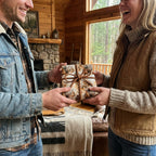 Woman receiving a gift wrapped in rustic horse-themed wrapping paper with braided twine ribbon.