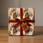 Gift wrapped in cowboy pattern paper with an orange velvet ribbon bow and "Cowboy Up" tag.