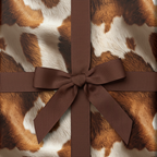 Brown ribbon on a cow print pattern wrapping paper, perfect for a rustic or country-themed gift.