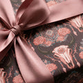 Boho skull wrapping paper with roses and a dusty rose satin bow, rustic gift wrap by Wrapped Studios.